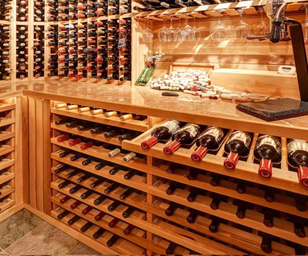 La cave à vin du restaurant présentant des bouteilles rangés dans des casiers en bois claires