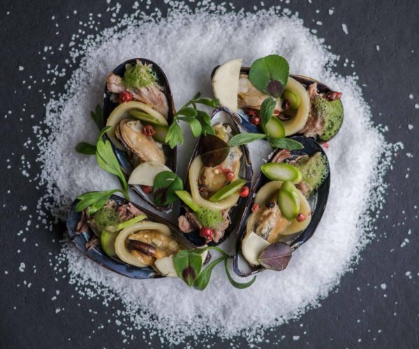 Assiette de moules garnies de légumes sur lit de sel déposé dans une assiette ardoise - Bordeaux